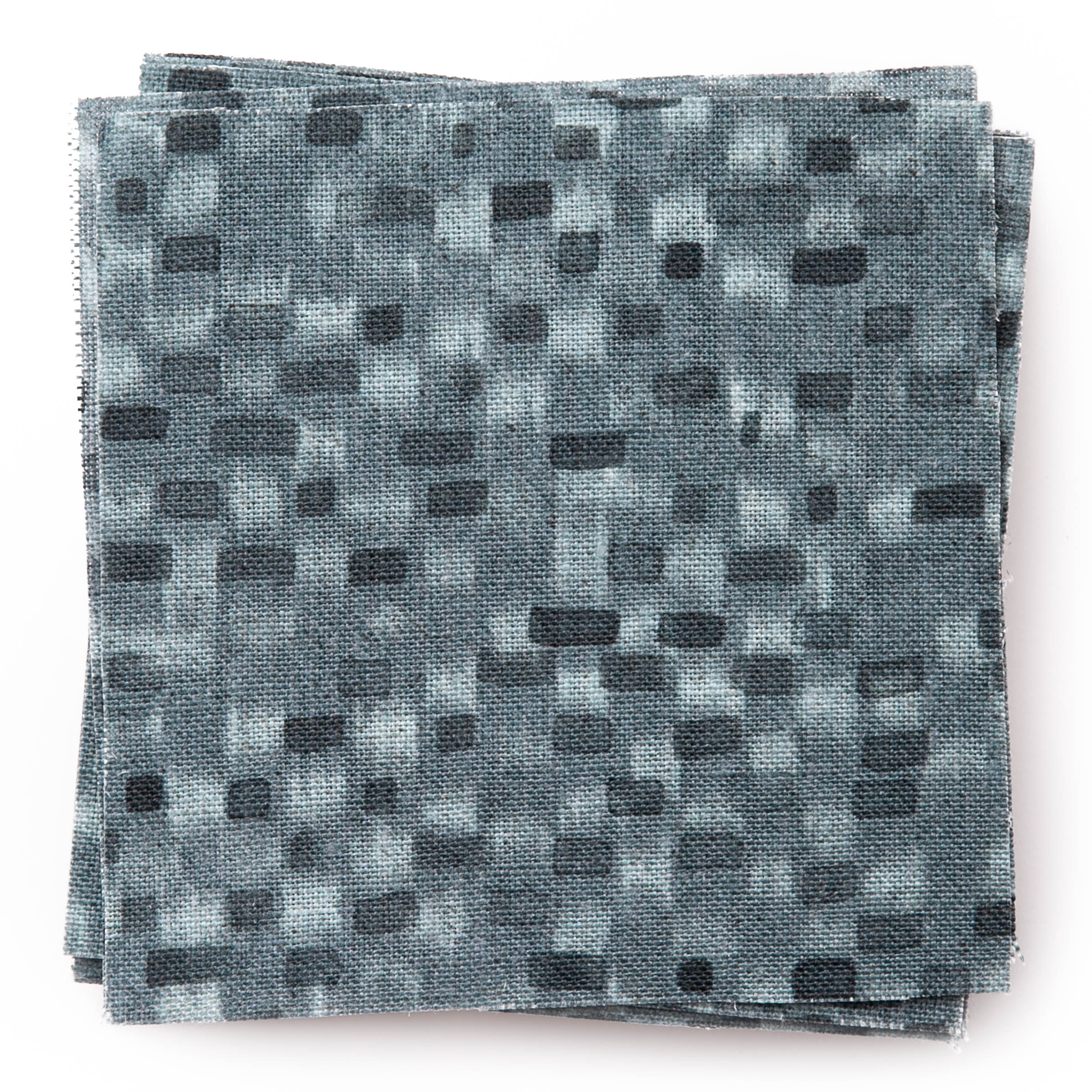 A stack of fabric swatches in a painterly checked pattern in shades of blue and navy.