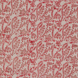 Detail of fabric in a dense floral print in red and tan on a cream field.