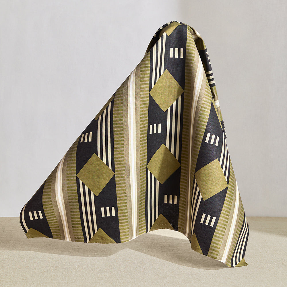 Hanging fabric piece in a graphic geometric design in sage green, taupe, white and black.