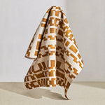 Draped fabric in a modernist checkerboard pattern in yellow ochre and cream.