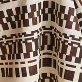 Draped fabric in a modernist checkerboard pattern in brown and cream.