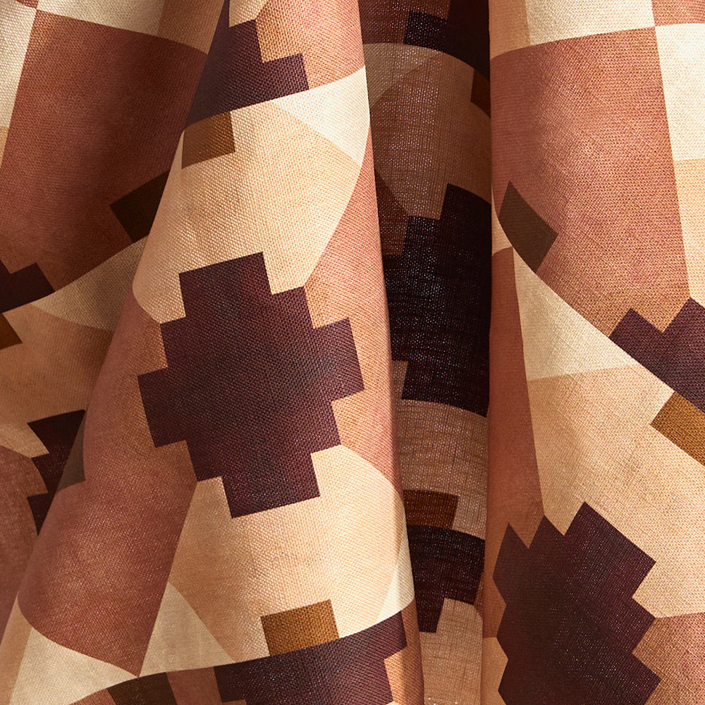 Draped fabric in a bold abstract checkerboard pattern in blush, oxblood, camel and cream.