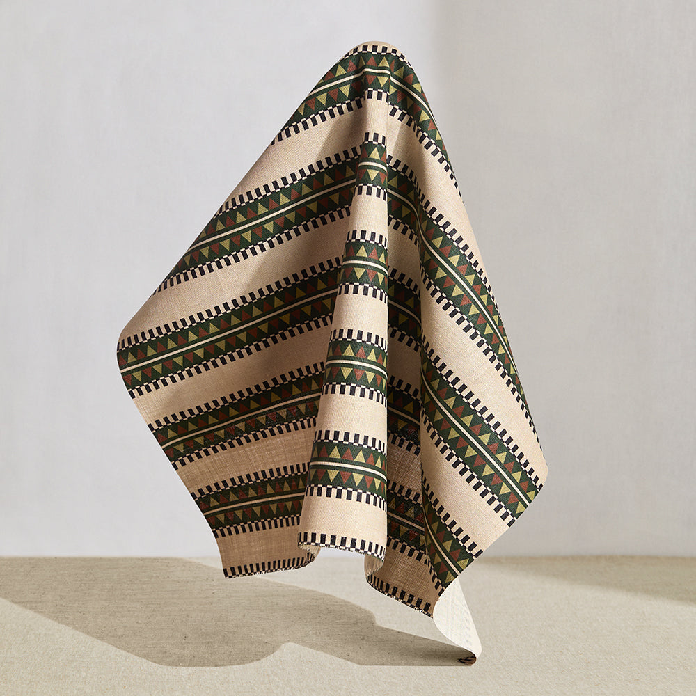 Draped fabric in a complex geometric stripe in green, brown and sage and black on a cream field.