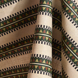 Fabric in a complex geometric stripe in green, brown and sage and black on a cream field.