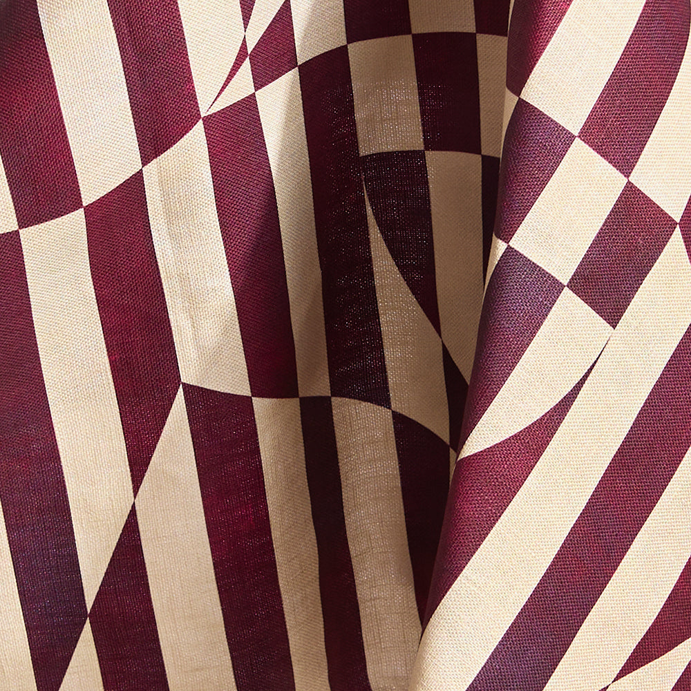 Draped fabric in a trompe l'oeil stripe pattern with geometric shapes in cream and burgundy. 