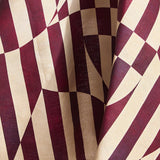 Draped fabric in a trompe l'oeil stripe pattern with geometric shapes in cream and burgundy. 