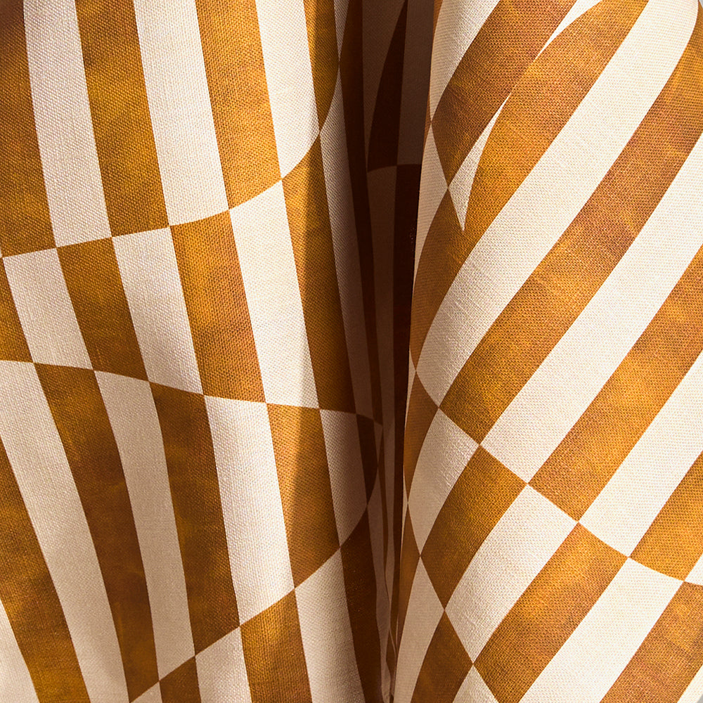 Draped fabric in a trompe l'oeil stripe pattern with geometric shapes in cream and ochre.