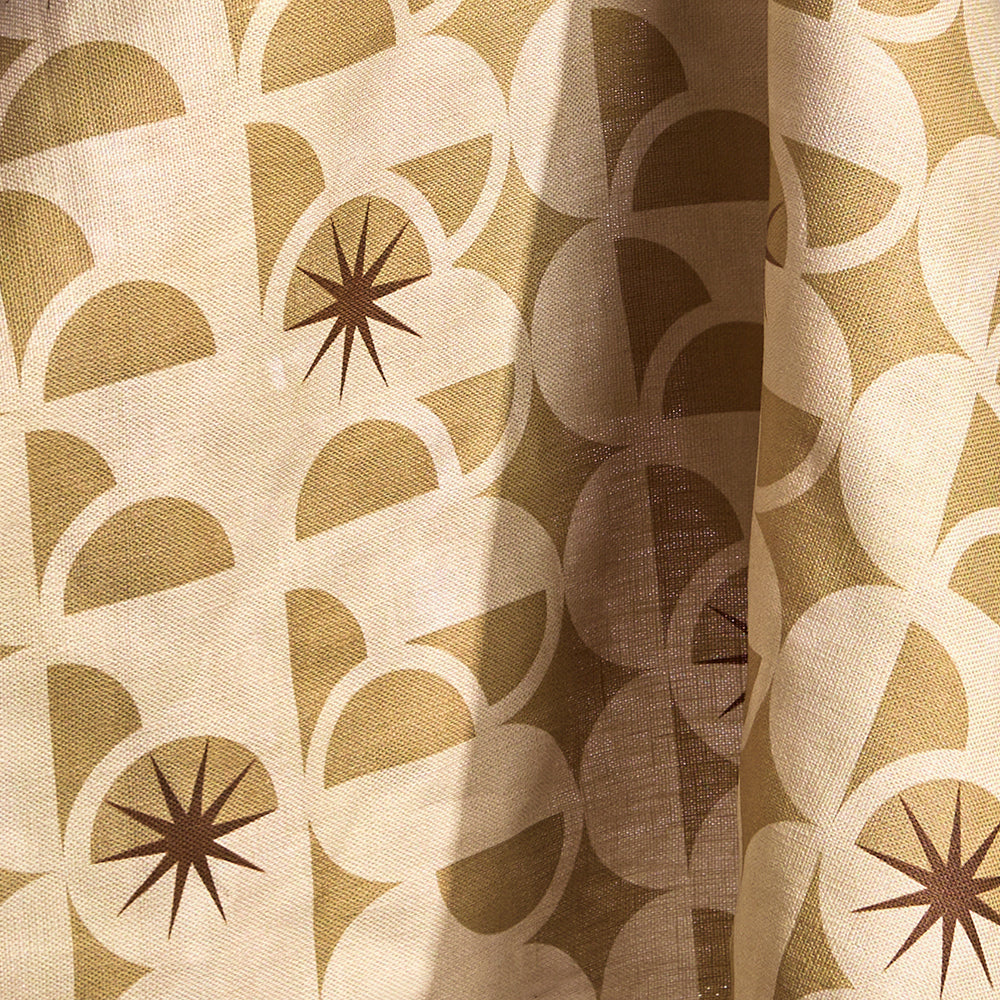 Fabric in a curvilinear art deco inspired pattern in taupe, beige and brown.