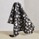 Draped fabric in a curvilinear art deco inspired pattern in black, grey and white.