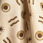 Fabric in a graphic geometric pattern of circles, stars and stripes in taupe and brown on a cream field.