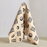 Hanging fabric in a graphic geometric pattern of circles, and stripes in black and grey on a cream field.