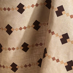 Fabric in a stripe in a stacked diamond design in pink with dark brown accents.
