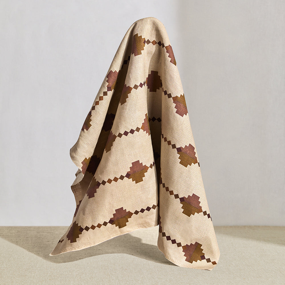 Hanging fabric in a stacked diamond stripe design in pink and ochre with purple accents.