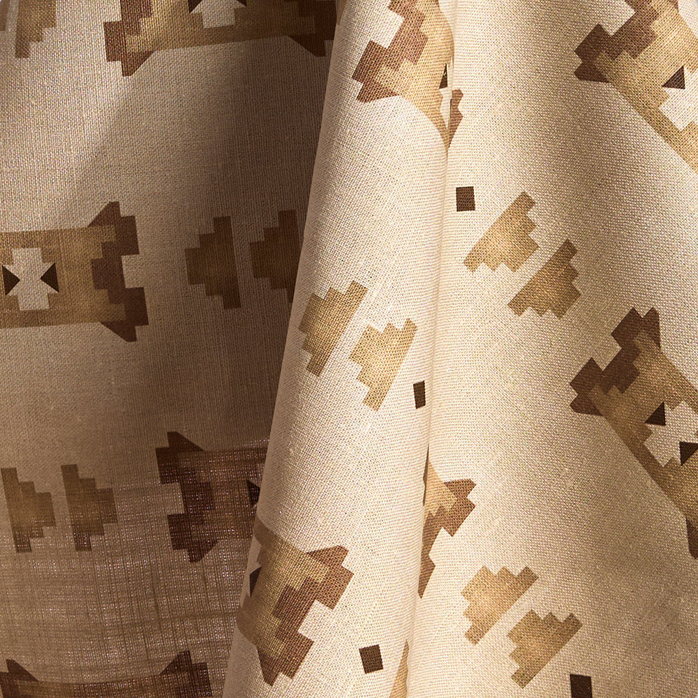 Fabric in a geometric stair step pattern in brown and tan on a cream field.