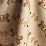 Fabric in a geometric stair step pattern in brown and tan on a cream field.