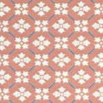 Detail of fabric in a repeating floral lattice print in white and blue on a coral field.