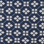 Detail of fabric in a repeating floral lattice print in blue and cream on a navy field.