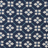Detail of fabric in a repeating floral lattice print in blue and cream on a navy field.