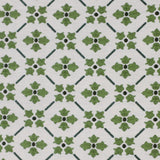 Detail of fabric in a repeating floral lattice print in shades of green on a white field.