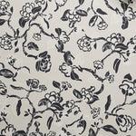 Close up of wallpaper in a hand drawn branch and flower design in black and white on beige. 