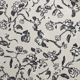 Close up of wallpaper in a hand drawn branch and flower design in black and white on beige. 