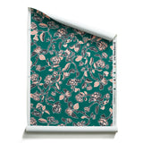 Roll of wallpaper in a hand drawn branch and flower design in black and pink on emerald green. 