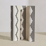 Wallpaper roll in a graphic geometric design in ecru, cream and black. 