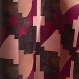 Wallpaper in a bold abstract checkerboard pattern in brown, tan, pink and fuchsia.