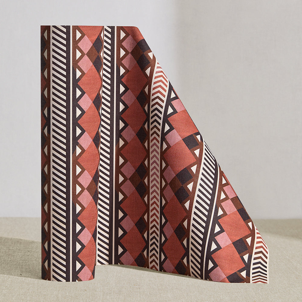 Wallpaper roll in a complex stripe with geometric shapes and chevrons in clay, lilac, brown and cream.