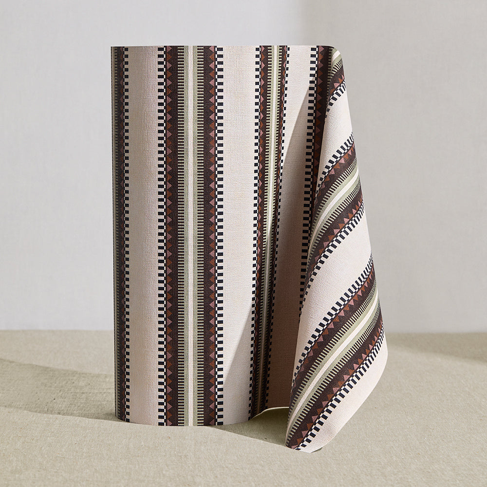 Wallpaper roll in a complex geometric stripe in brown, tan, orange, light purple and black on a cream field.
