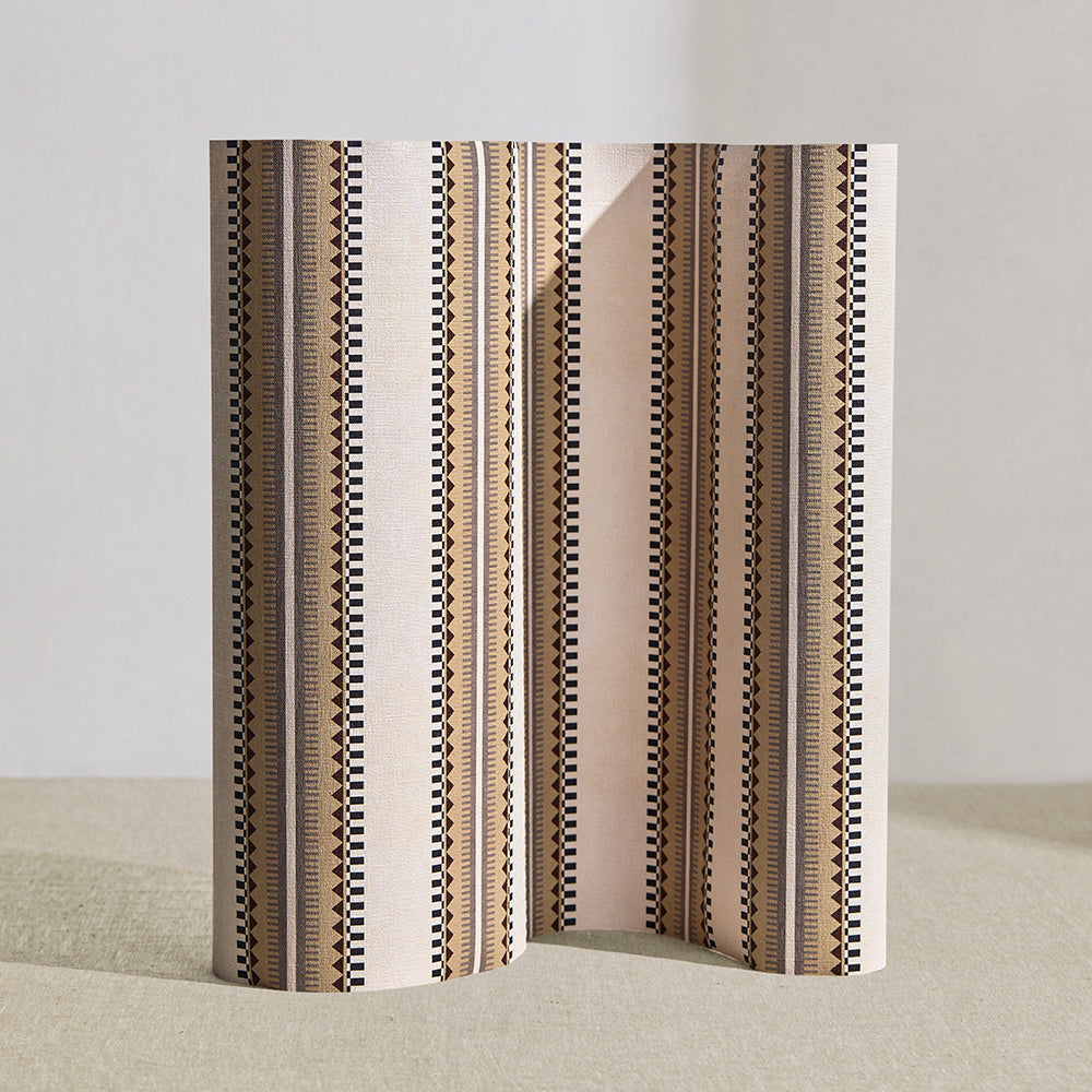Wallpaper roll in a complex geometric stripe in brown, tan, taupe and black on a cream field.