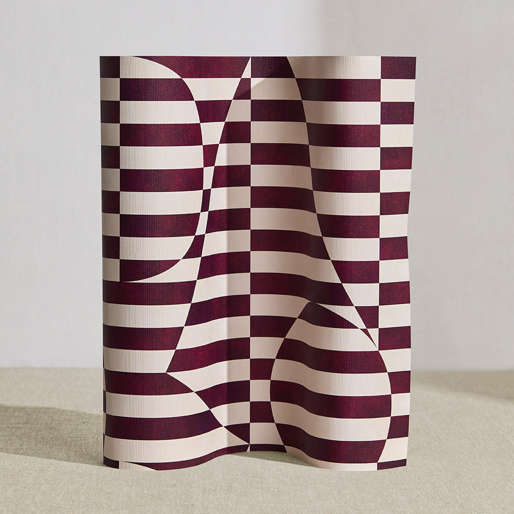 Wallpaper roll in a trompe l'oeil stripe pattern with geometric shapes in cream and burgundy. 