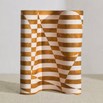 Wallpaper roll in a trompe l'oeil stripe pattern with geometric shapes in cream and ochre.