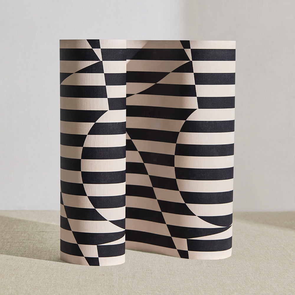 Wallpaper roll in a trompe l'oeil stripe pattern with geometric shapes in cream and black.