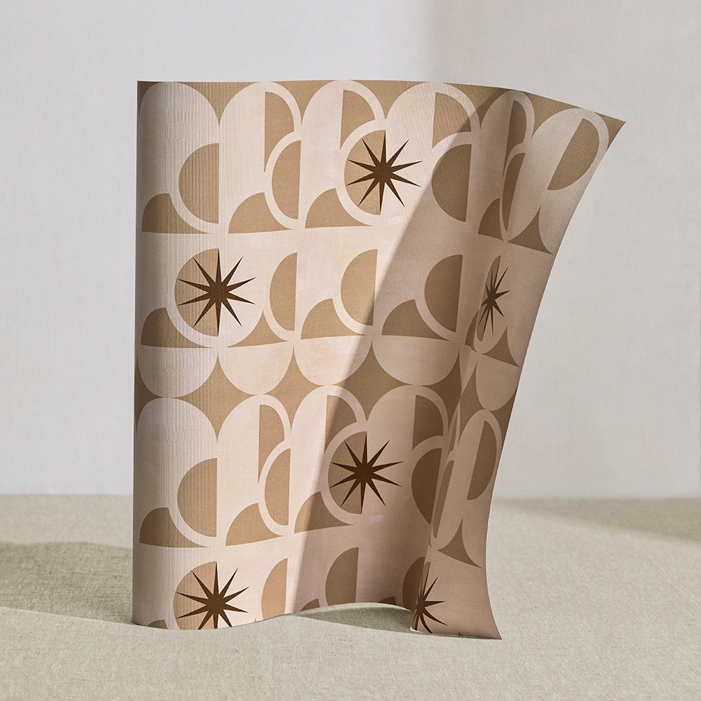 Wallpaper roll in a in a curvilinear art deco inspired pattern in taupe, beige and brown.