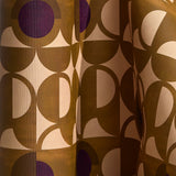 Wallpaper in a curvilinear art deco inspired pattern in ochre, beige and purple.