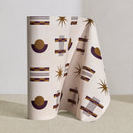 Wallpaper roll in a graphic geometric pattern of circles, stars and stripes in purple and ochre on a cream field.