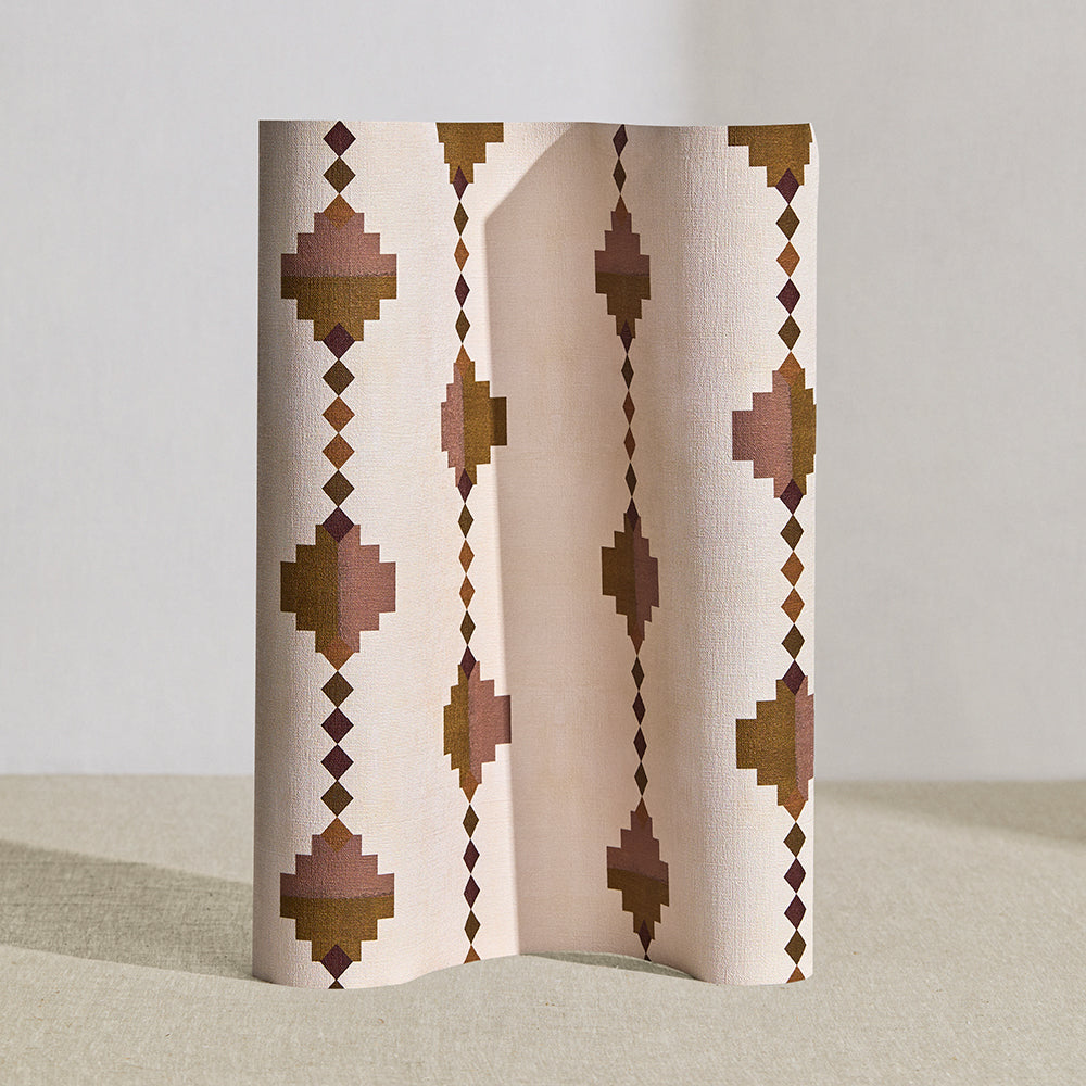 Wallpaper roll in a stacked diamond stripe design in pink and ochre with purple accents.