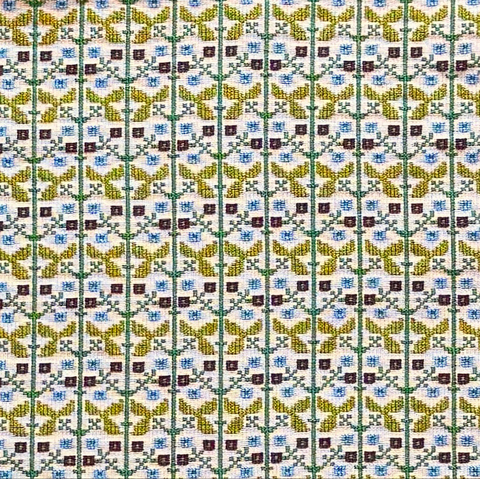 Patterned fabric with a gridded floral design in green, yellow and blue. 