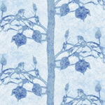 Detail of fabric in a linear tree and leaf print in navy on a light blue field.