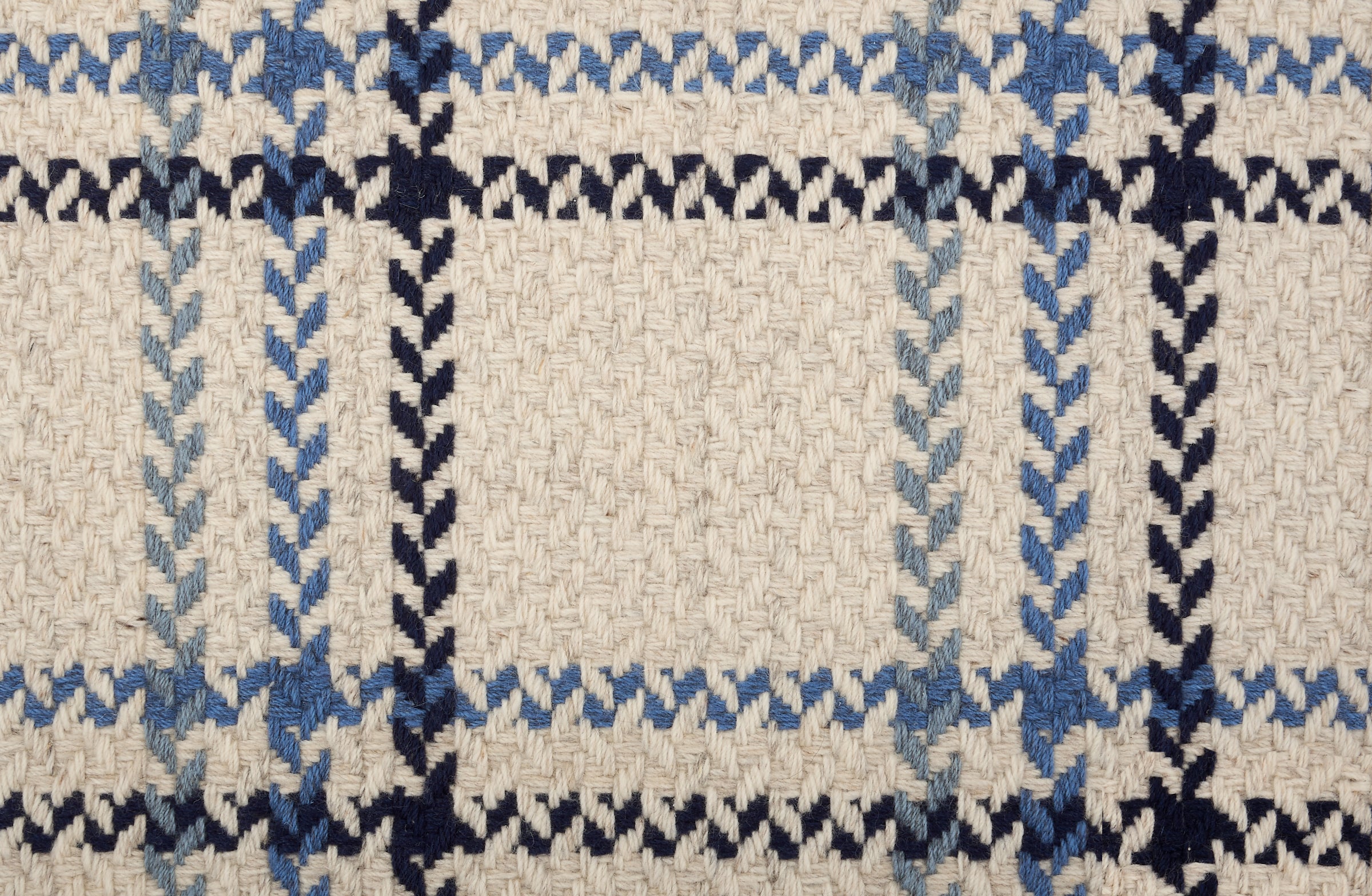 Broadloom carpet in a windowpane plaid in shades of blue on a beige field.