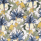 Detail of fabric in a dense floral print in shades of cream, yellow, green and blue on a white field.