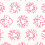 Detail of fabric in a repeating circular geometric print in pink on a white field.