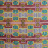 Close up of printed fabric with a complex geometric and striped pattern with pink, orange, turquoise and red. 