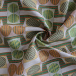 Close up of gently draped printed fabric with a complex geometric and striped pattern with orange, brown, grey and green.