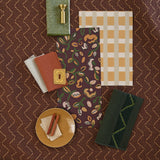 Moodboard with layered swatches of fabrics and inspiration images in palette of  brown, green and tan. 