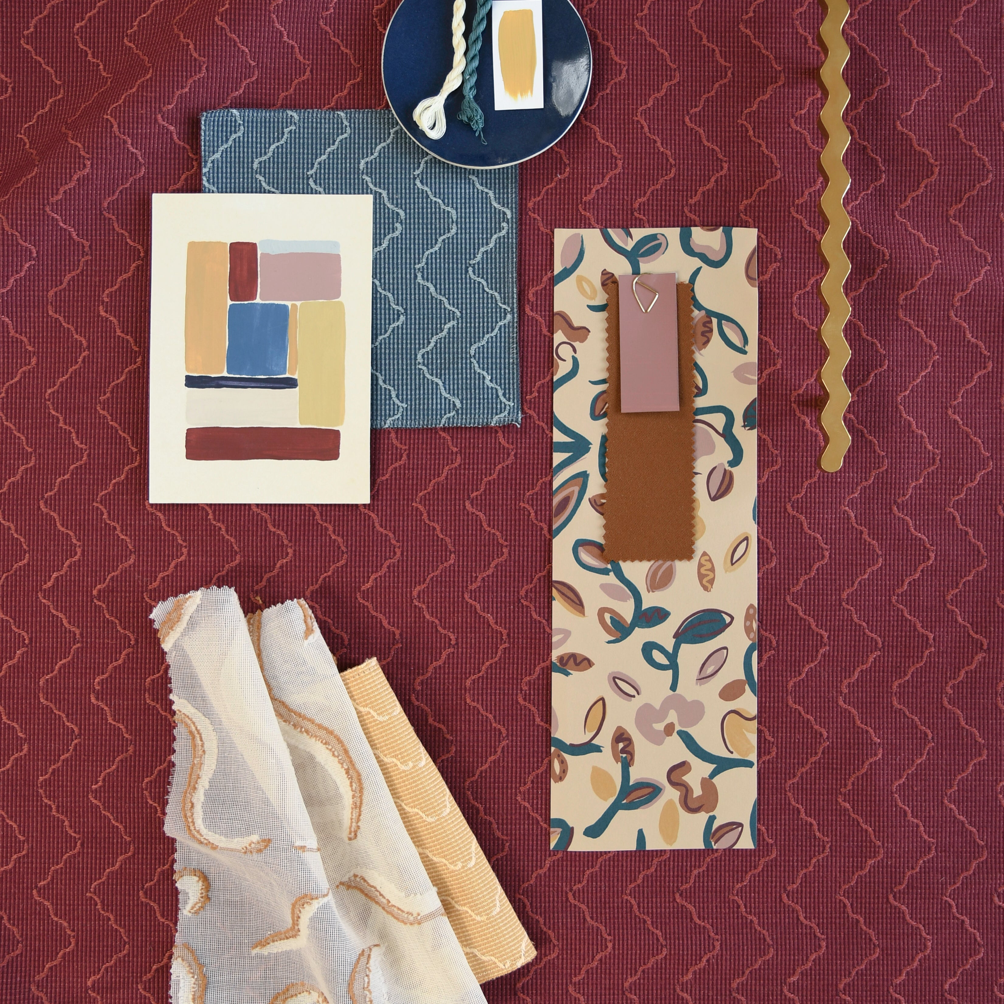 Moodboard with layered swatches of fabrics and inspiration images in palette of red, yellow and pink,