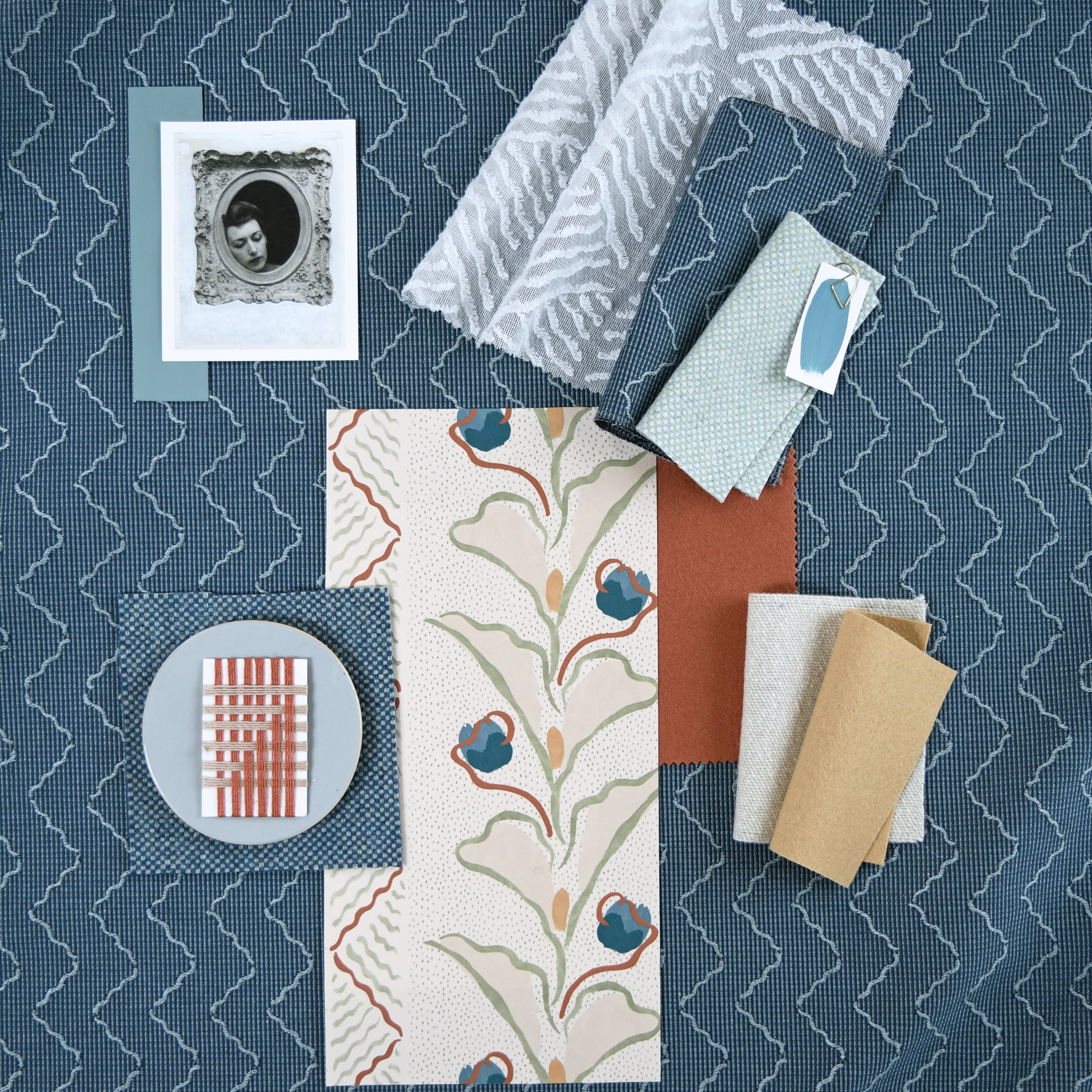 Moodboard with layered swatches of fabrics and inspiration images in palette of blue. 