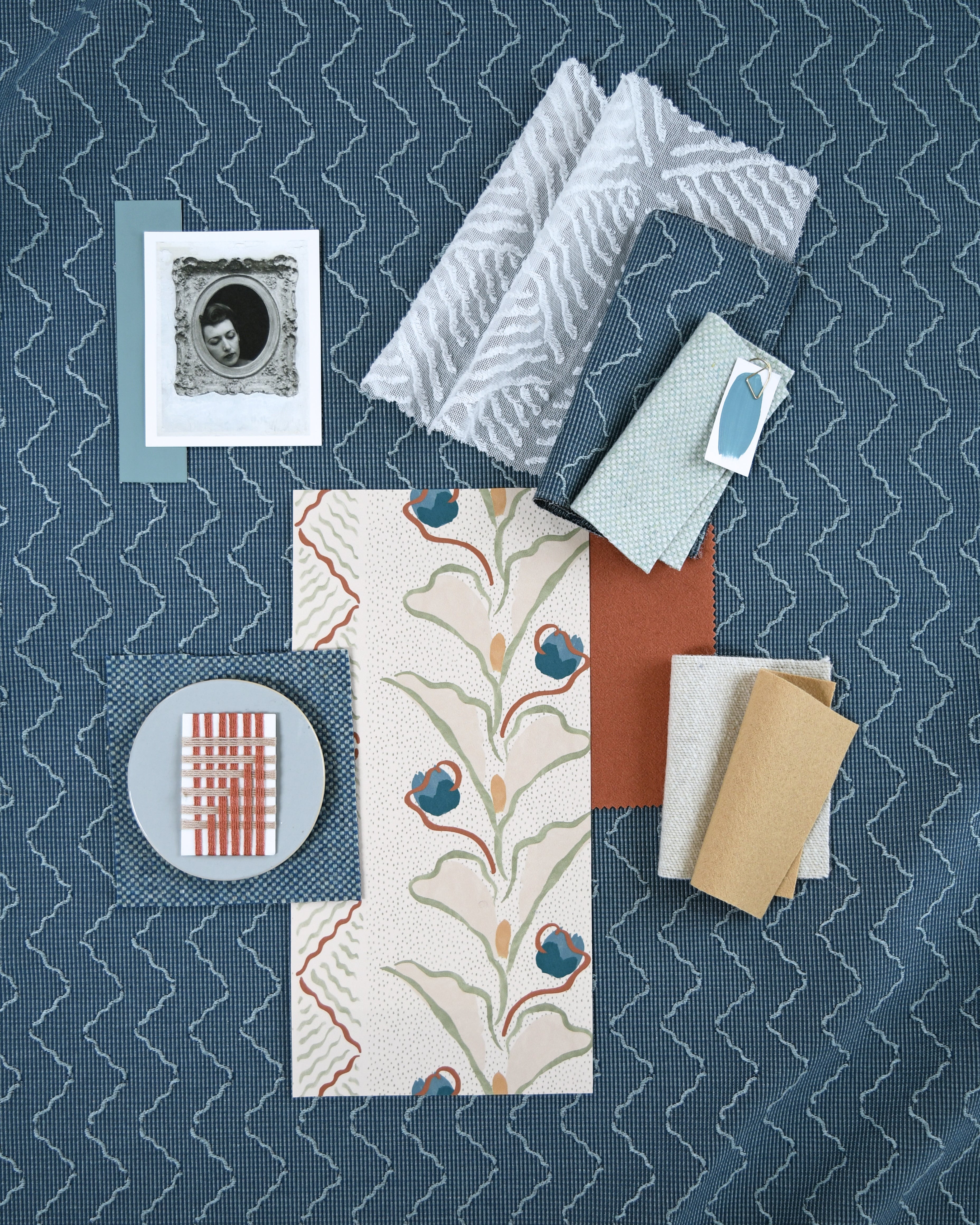 Moodboard with layered swatches of fabrics and inspiration images in palette of blue. 