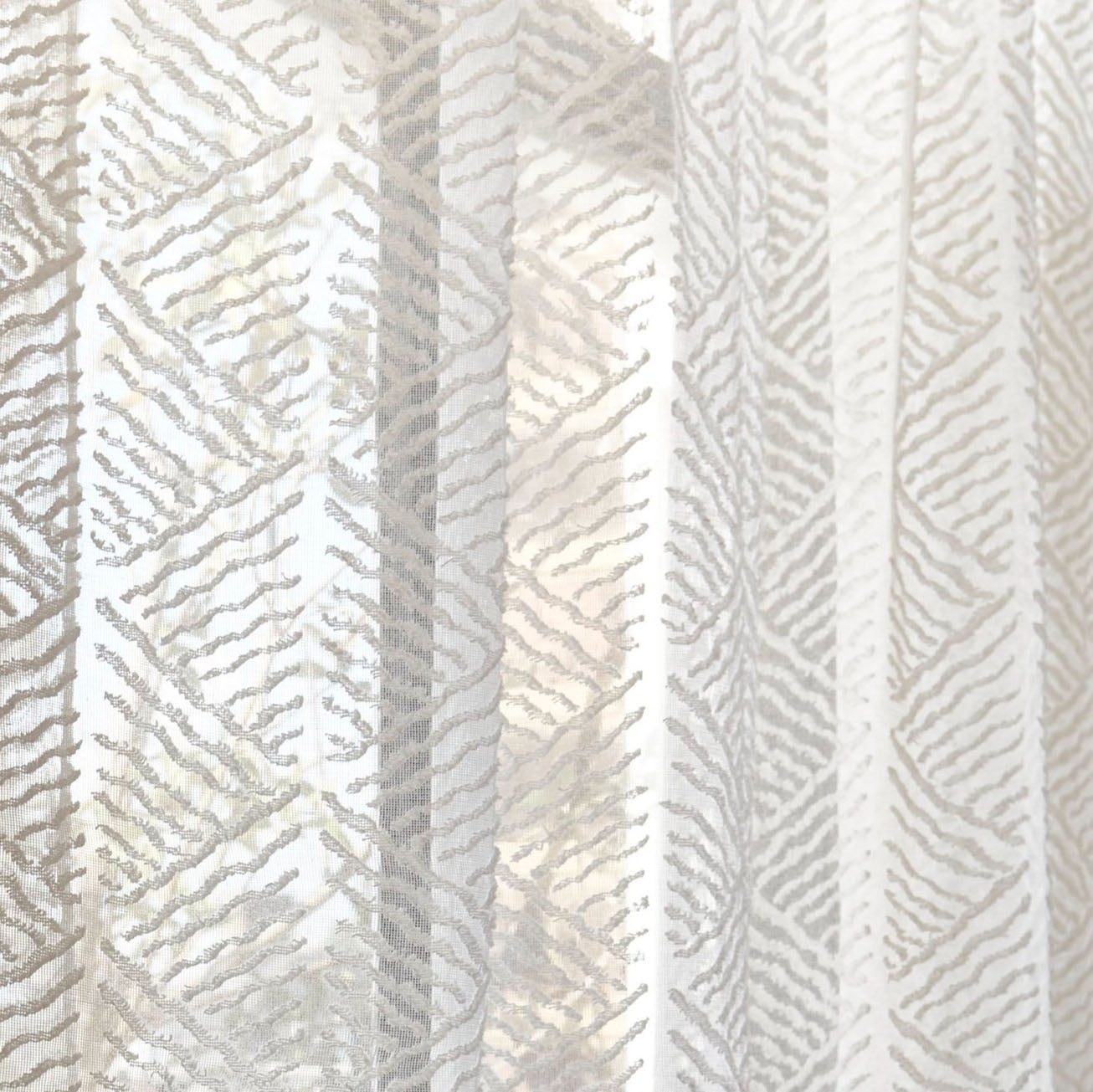 Draped sheer fabric in a diamond wavy lined diamond pattern in ivory.